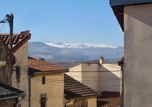 a view of snowy mountains from the roofs of buildings at La maison du vieux bourg in Perrier