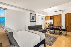 a bedroom with a bed and a table and a kitchen at Harbor 171 TN 2110 in Puerto Vallarta