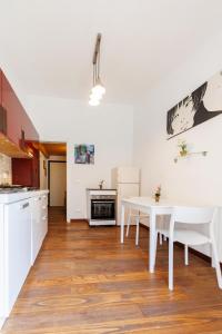 a kitchen and dining room with a table and a white table and chairs at Via Fiorenza Apartment in Livorno