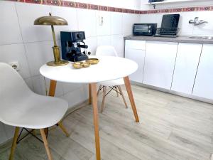 un tavolo bianco con una macchinetta del caffè in una cucina di Angelina apartmani. a Vračar (historical)