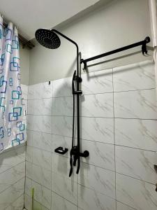 eine Dusche im Bad mit einer weiß gefliesten Wand in der Unterkunft Supreme Apartments in Kansiri