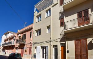 a building with a car parked in front of it at 2 Bedroom Gorgeous Apartment In Trappeto in Trappeto