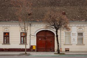 a building with a large wooden door and two trees at AMS Cluj Central Stay Boutique in Cluj-Napoca