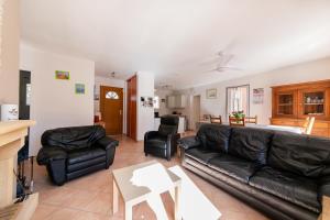 - un salon avec un canapé et des fauteuils en cuir noir dans l'établissement Montgit - Piscine grand jardin parking, à Montmeyan