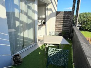 a patio with a white table and chairs on a balcony at Appartement Cosy avec Balcon in Parentis-en-Born
