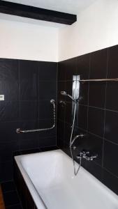 a bath tub in a bathroom with black tiles at Fischerhaus am See in Berlin +13 photos