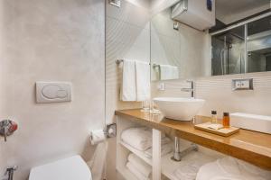 y baño con lavabo, aseo y espejo. en Shali Luxury Suite Spagna, en Roma