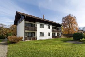 a large white house with a grass yard at Ferienwohnanlage Oberaudorf C 2 mit Hallenbad und Sauna in Oberaudorf