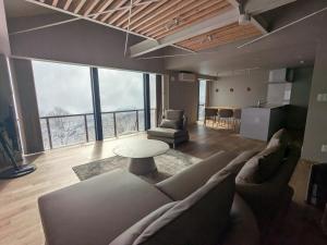 a living room with a couch and a table at Aki's Apartments Madarao in Iiyama