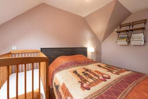 a bedroom with a bed with a wooden crib at Maison confortable près de la Forêt de Brocéliande, BBQ in La Chapelle-Caro