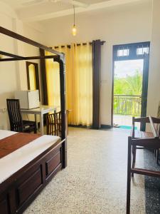 Un dormitorio con una cama y una mesa y sillas. en Green Palace Mirissa, en Mirissa