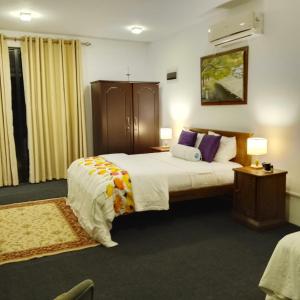 a hotel room with a large bed and two lamps at High Rise in Kandy