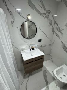 a white bathroom with a sink and a mirror at Madryn al Mar in Puerto Madryn