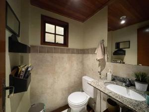 a bathroom with a toilet and a sink and a window at Casa Cacau - Guest house a 700m metros de geriba in Armacao dos Buzios +32 photos