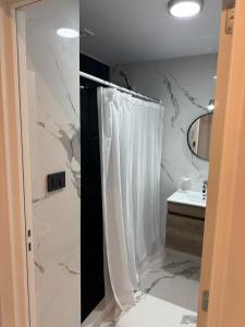 a bathroom with a shower curtain and a sink at Madryn al Mar in Puerto Madryn +15 photos