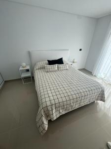 a bedroom with a bed with a checkered blanket at Madryn al Mar in Puerto Madryn