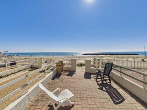 two white chairs sitting on a sidewalk near the beach at Studio cabine RDC, terrasse, 4 pers, parking - FR-1-423-26 in Le Grau-dʼAgde +5 photos