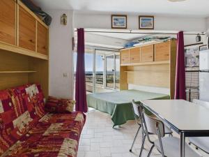 a living room with a bed and a table at Studio cabine RDC, terrasse, 4 pers, parking - FR-1-423-26 in Le Grau-dʼAgde