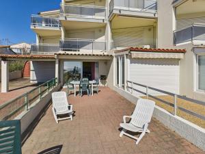 a patio with chairs and a table on a balcony at Studio cabine RDC, terrasse, 4 pers, parking - FR-1-423-26 in Le Grau-dʼAgde