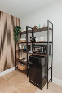 eine Küche mit einem schwarzen Regal und einer Mikrowelle in der Unterkunft Cozy Miami Suite with FREE Parking in Miami