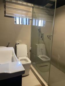 a bathroom with a toilet and a glass shower at Swiss pearl continental hotels and apartments in Abuja