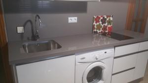 een keuken met een wastafel en een wasmachine bij Apartamento Eduardo Dato in Sevilla