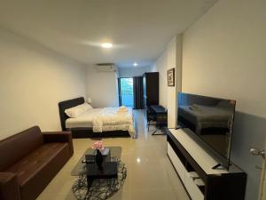 a small living room with a bed and a couch at ณัฐพิมลเพลส์ 3 in Bangkok Yai