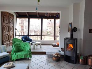 a living room with a fireplace and a green chair at Ca di Nà in Entracque