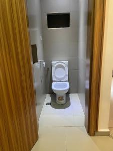 a bathroom with a white toilet in a stall at Swiss pearl continental hotels and apartments in Abuja