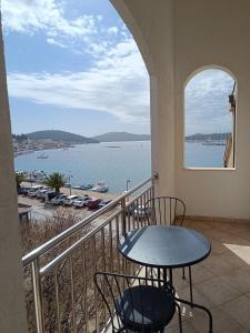 a balcony with a table and chairs and a view of the water at Sun-up in Rogoznica