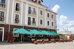 a patio area with tables, chairs and umbrellas at Reikartz Kamianets-Podilskyi in Kamianets-Podilskyi
