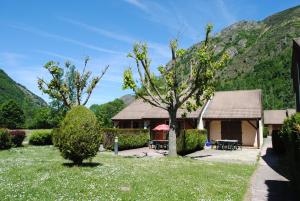 a house with a garden and mountains in the background at Chalets et gîtes d'Orlu in Orlu