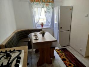 a small kitchen with a table and a refrigerator at Apartmán Eva in Vrbov