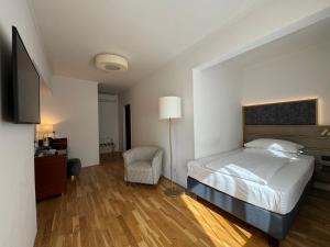 una camera da letto con un letto e una sedia di Hotel Secession an der Oper a Vienna