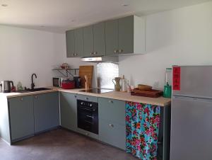 a kitchen with gray cabinets and a refrigerator at ricochets in Castillon