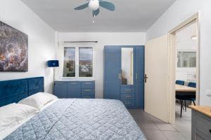a blue bedroom with a bed and a ceiling fan at The Greek Getaway in Lóngos