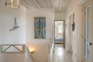 een hal met witte muren en een trap met een deur bij Coral Pearl in Isterni +35 foto's