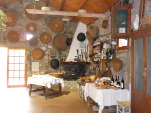 a kitchen with two tables and pots and pans at Aguadora in SantʼAntìoco