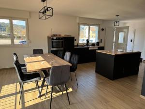 a kitchen and dining room with a table and chairs at Maison 8 personnes 4 Chambres Doubles - Piscine in Anould