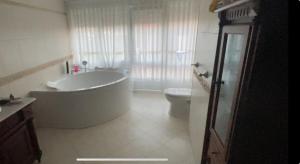 a bathroom with a large tub and a toilet at Casa de Ferreñas-5 dormitorios in Esteiro +6 photos