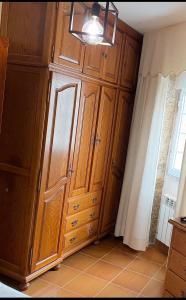 a large wooden cabinet in a room with a window at Casa de Ferreñas-5 dormitorios in Esteiro