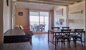 ein Wohnzimmer mit Tisch und Stühlen und einem Balkon in der Unterkunft St-Goustan à tribord - Les Gîtes de la Côte d'Amour in Le Croisic + 16 Fotos