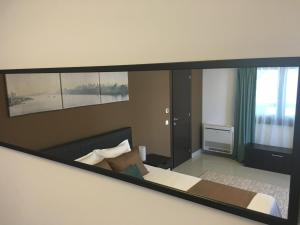 a mirror reflection of a bedroom with a bed and a window at Elysium in Bucharest