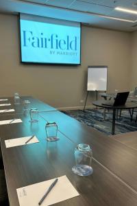 a conference room with a table with glasses and a screen at Fairfield by Marriott San Jose Airport Alajuela in Alajuela City