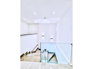 a staircase in a white room with a glass wall at The Park villa in Madinaty