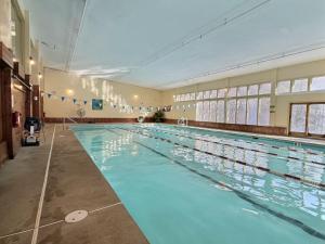 a large indoor swimming pool with blue water at Alpine Chalet Grill, Fire pit, Pool, Gym, CornHole in Killington