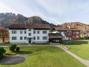 ein großes weißes Haus mit einem Rasenplatz in der Unterkunft Ferienwohnanlage Oberaudorf E3 mit Hallenbad und Sauna in Oberaudorf