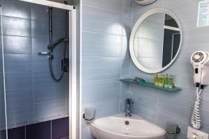 uma casa de banho com um chuveiro, um lavatório e um espelho. em Hotel Concorde em Bellaria-Igea Marina