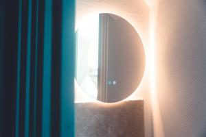 a mirror on the side of a wall with a light at L'Unique- Maison de famille en Plein Centre-Ville in Tours