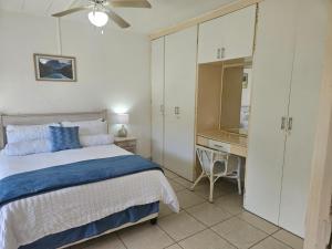 un dormitorio con una cama y un escritorio en Eden Wilds No 19 Rennies Beach Port Edward, en Port Edward 53 fotos más